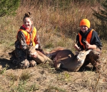 2 youth hold their deer heads after harvesting from a youth hunt