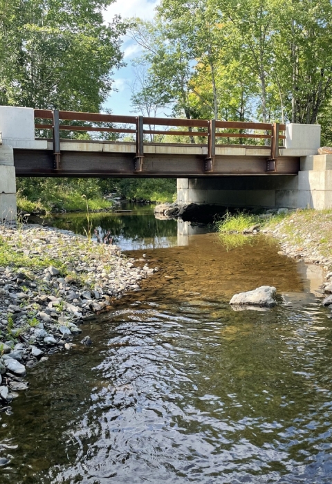 newly constructed bridge rests atop concrete blocks to cross the river 