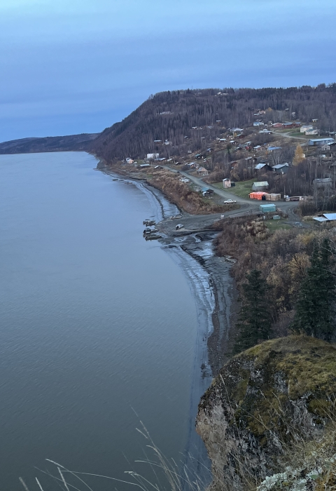 Landscape picture of a town next to a large body of water with an overcast sky