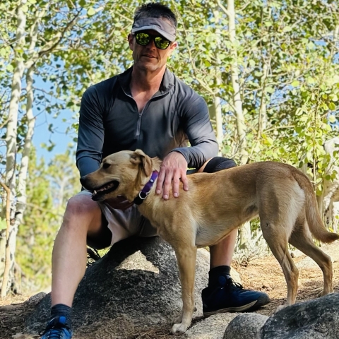 Person standing with a dog outside.