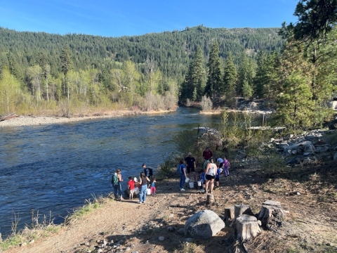 A group of people gather near the river