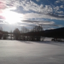 Snow covered hills at Little Pend Oreille National Wildlife Refuge, with sun streaming through scattered clouds. 