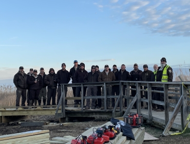 a group of people stand on a boardwalk during a construction project