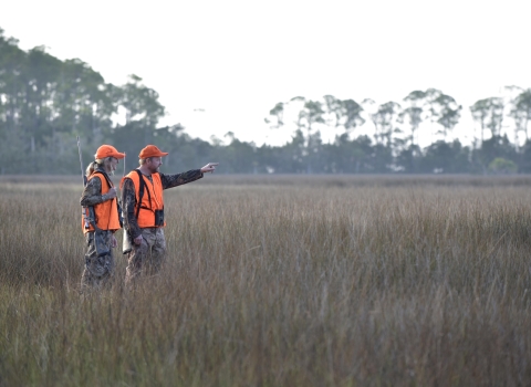 Two hunters standing in the field.