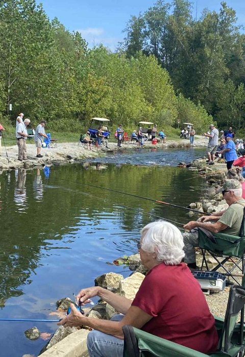 Elderly people fishing at stream