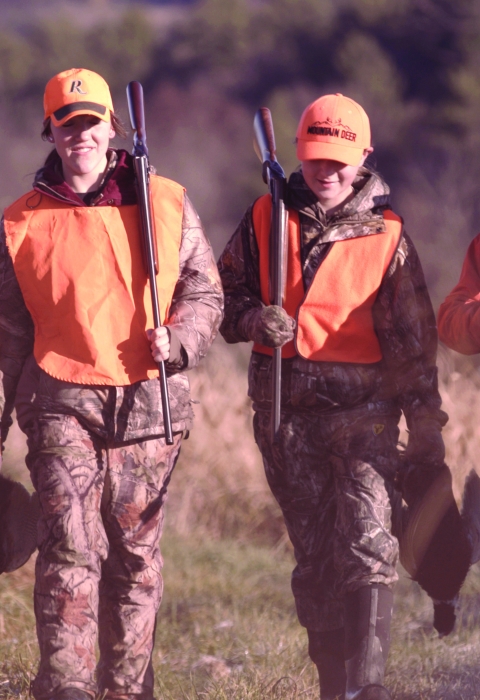 Four hunters in blaze orange walking after a pheasant hunt