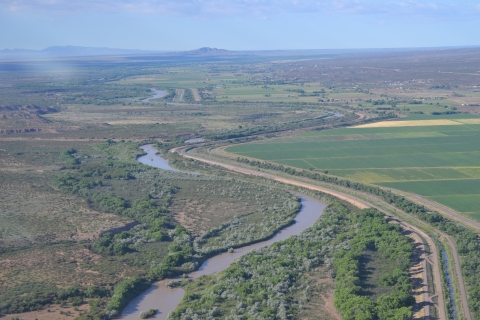 A winding river next to fields and agricultural land