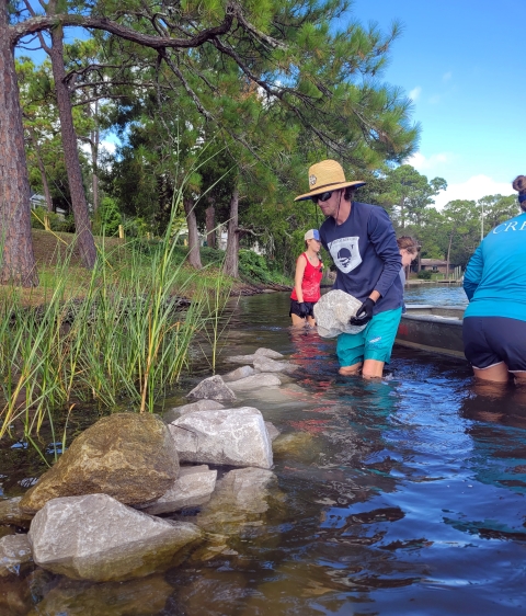Choctawhatchee Basin Alliance staff building a living shoreline with Spartina alterniflora growing behind the reef.