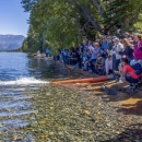 a group of people standing next to a lake 