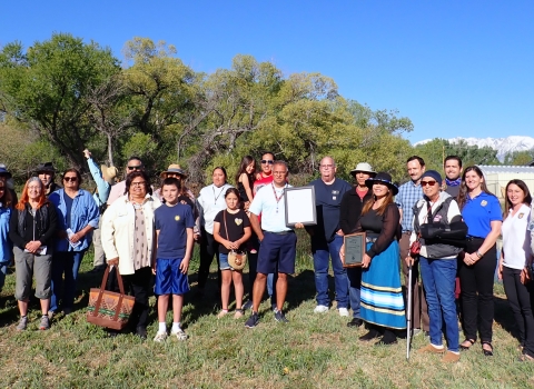 A group of people stand for a group photo outside.