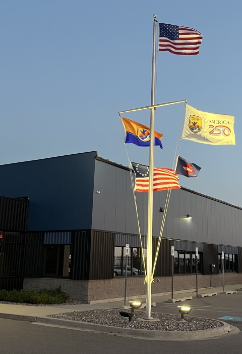 5 flags on flag pole with US at top