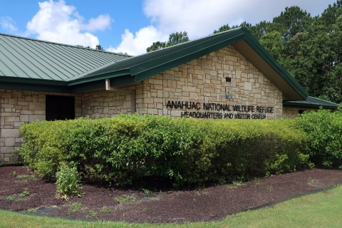 The Jocelyn Nungaray National Wildlife Refuge visitors center is shown with bushes in front.