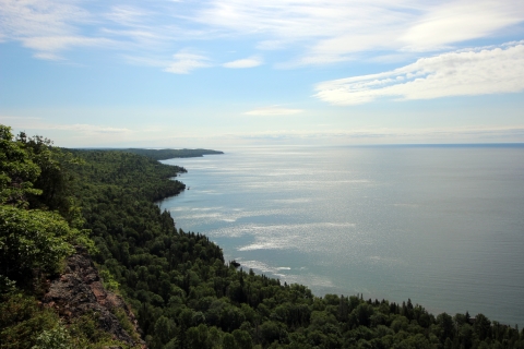 A forested coastline along a large lake.