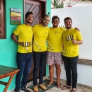 Four people in yellow t-shirts are holding power line markers