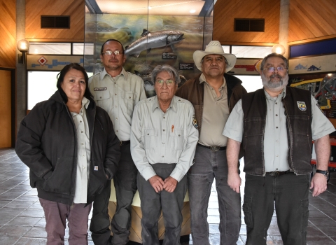 Five people stand in a row wearing USFWS logo uniform clothing.