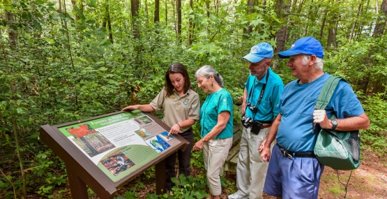 FWS Visitor services staffer shows interpretive panel to visitors