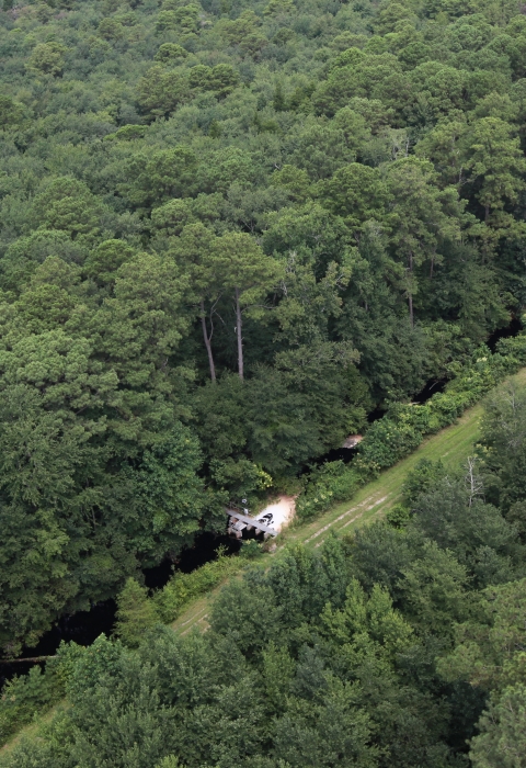 A metal water control structure dams a ditch and prevents water from flowing out. 