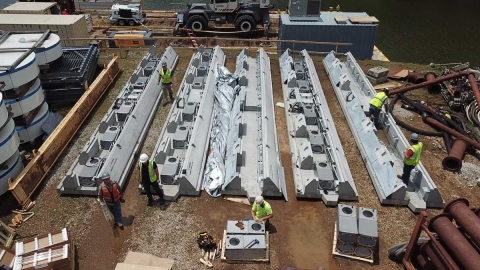 Construction workers install a bio-acoustic fish fence