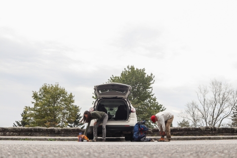 Two people in a parking lot changing shoes