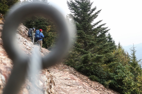 Two people standing on a trail looking out over a mountain vista
