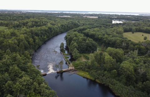 Aerial view of waterway obstructed by dam.