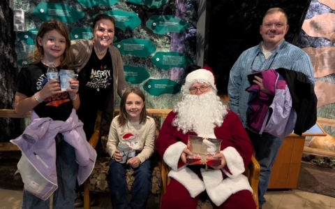 Family posing for a photo with Santa