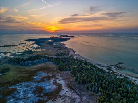 Aerial view of Waugoshance Point in Wilderness State Park on Lake Michigan at sunset in winter.