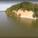 White cliffs capped with bright green trees. The cliffs are adjacent to a wide river.