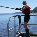 Woman on boat with fish net in hand on Mississippi river.