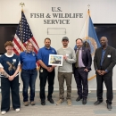 2024 National Junior Duck Stamp Art Contest judges holding the winning artwork