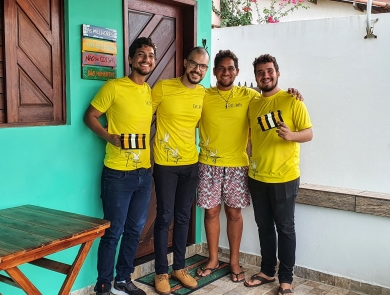 Four people in yellow t-shirts are holding power line markers