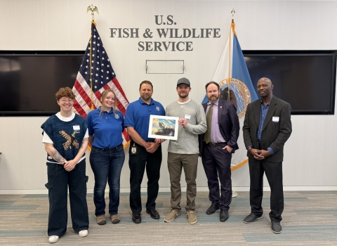 2024 National Junior Duck Stamp Art Contest judges holding the winning artwork
